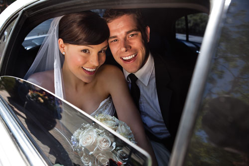 bride and groom in a limo at wedding